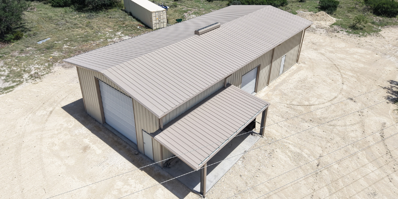 Aerial view of a metal warehouse showing a raised vent near the center of the roof.