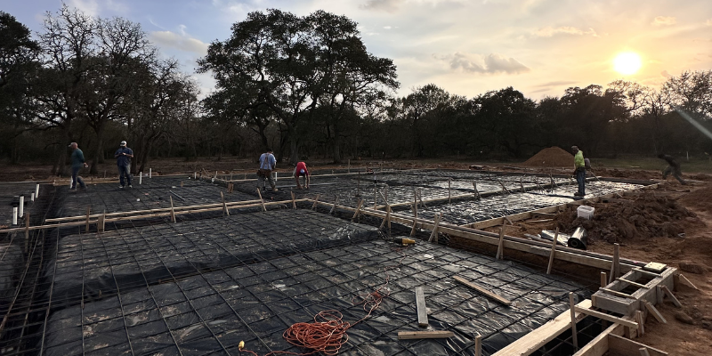 metal building sitework with slab preparation and crew highlighting sitework uncertainty before construction