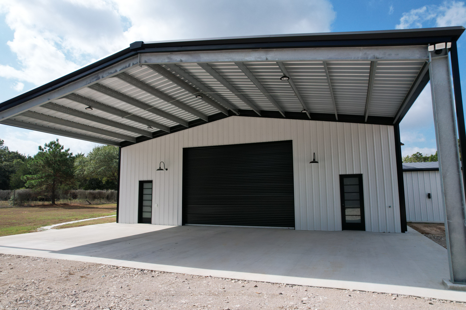 metal building with roll up door and canopy for equipment storage in Texas