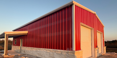 finished pre-engineered metal building shop in Texas with roll-up doors and covered entry