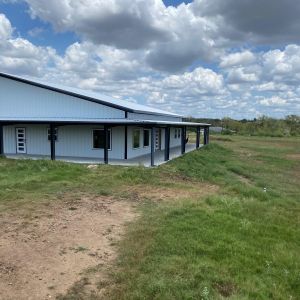 modern-white-metal-barndominium-wraparound-porch-rural-texas